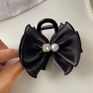 Détail de la pince à cheveux noeud en soie noire avec cristal et perle