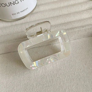 Détail d'une pince à cheveux rectangulaire en résine aux reflets nacrés et irisés