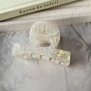 Détail d'une pince à cheveux en acétate nacré avec texte doré Barrette La France