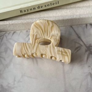 Détail de la grande pince à cheveux en acétate marbré avec lettrage doré Barrette La France