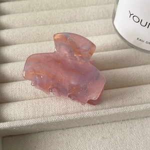Detailaufnahme der Haarklammer aus Harz mit rosa Marmorierung und Goldglitzer