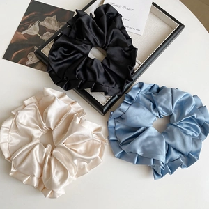 Détails des chouchous en satin de couleurs noir, blanc nacré et bleu clair