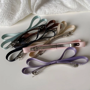 Close-up of six colorful satin ribbon bow hair clips with metal spring fasteners