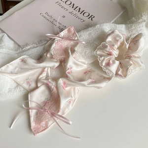 Ensemble chouchou en satin fleuri rose avec dentelle et rubans élégants sur tissu blanc