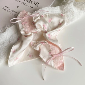 Détail de chouchou en soie à fleurs roses avec bordure en dentelle et nœuds satin