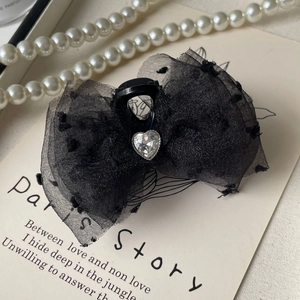 Detail of black polka dot lace bow hair claw with sparkling heart rhinestone