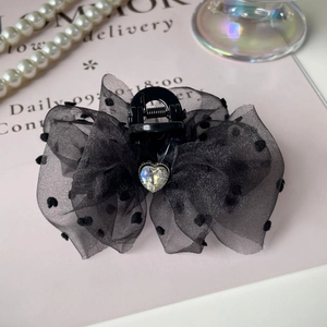 Detail of black polka dot tulle bow hair claw clip with heart shaped rhinestone accent