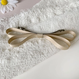 Close-up of champagne satin double-layered bow hair clip with a metallic spring clasp