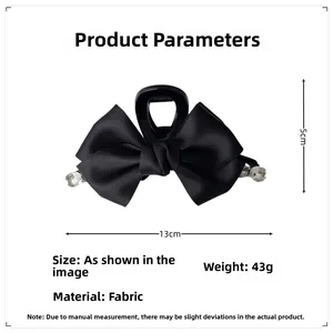 Detail view of a black ribbon bow hair claw with crystals, measuring 13cm and 43g