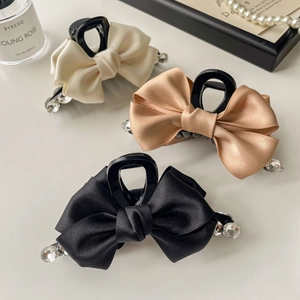 Elegant satin bow hair claw clips with diamond accents in cream, champagne, and black