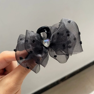 Close-up of black tulle polka dot bow hair claw with a sparkling heart rhinestone center