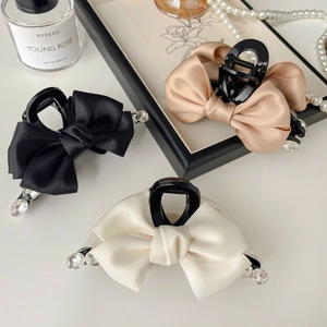 Three elegant satin bow hair clips with rhinestones in black, beige and champagne tones