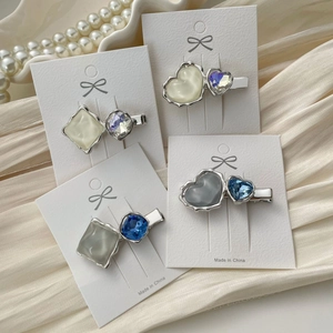 Elegant heart and geometric crystal hair clips on a satin background with pearls