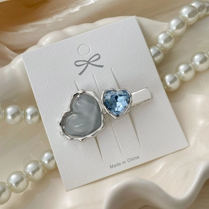 Detail of dual heart hair clip with grey resin and blue crystal in silver setting