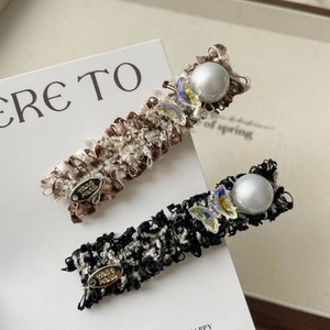 Detail of tweed hair clips with faux pearls, iridescent butterflies and handmade metal tag