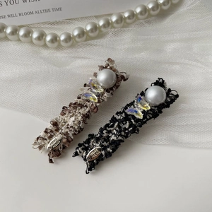 Detail of tweed hair clips with faux pearls and colorful butterfly charm accents