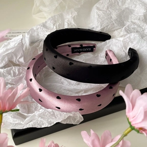 Vue détaillée de serre-têtes en satin faits main avec motifs de cœurs floqués noirs et roses