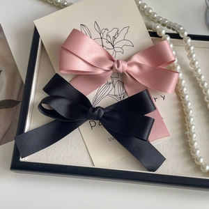 Pink and black satin bow hair clips in a vintage French style for elegant hairstyles