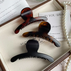 Vue détaillée de trois pinces à cheveux vintage de 11 cm en écaille, ambre et noir mat