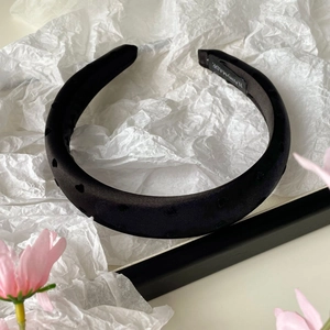 Détail du serre-tête en satin noir à motifs de cœur avec étiquette de fabrication artisanale