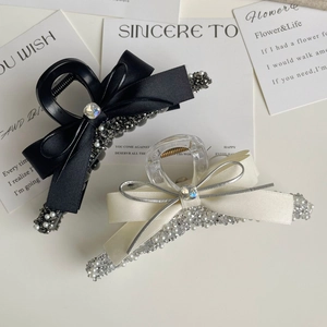 Detailed view of elegant silver beaded bow hair claws with pearl and rhinestone accents
