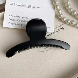 Gros plan d'une pince à cheveux noire mate de 11cm avec dents antidérapantes de luxe