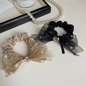 Détail de chouchous à nœuds élégants avec strass et finition satinée en noir et doré