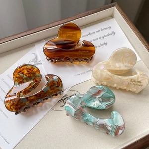 Elegant medium acetate hair claws in amber, pearl, marble, and ink patterns