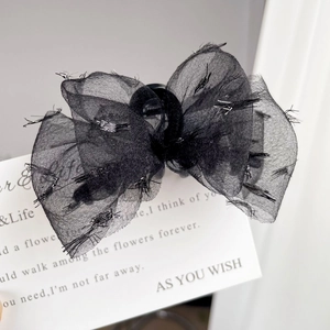 Pince à cheveux élégante en tulle noir avec fils pailletés argentés sur carte