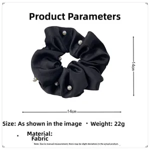 Detail view of 14cm black satin scrunchie with elegant faux pearl accents for hair styling