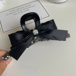 Detail of black ribbon bow hair claw clip with large square rhinestone and pearls