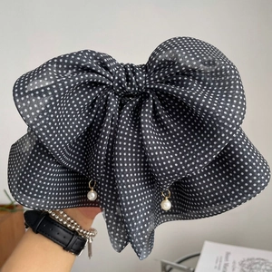 Detail of vintage polka dot bow hair claw clip with elegant white pearl pendants