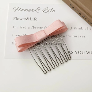 Détail d'un peigne à cheveux à nœud rose avec 10 dents en fil métallique pour femmes