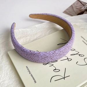 Detail of lavender satin headband with brown speckle pattern on a book