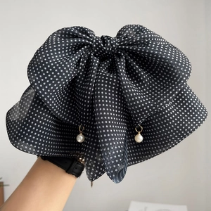 Detail of vintage polka dot chiffon bow clip with hanging pearl accents