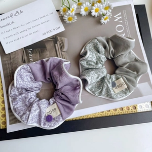 Détail de chouchous floraux avec coutures contrastées, étiquettes en tissu et boutons déco
