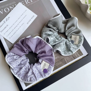 Détail de chouchous à fleurs bicolores avec tissu satiné et boutons décoratifs