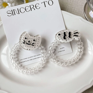 Élastiques à cheveux spirale avec pendentifs chat et poisson sur plat blanc