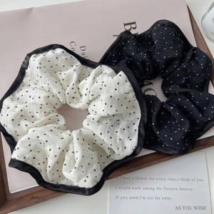 Close-up of elegant polka dot scrunchies in black and white with contrast stitching