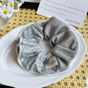 Détail d'un chouchou en patchwork floral avec bouton décoratif sur assiette