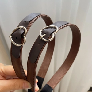 Detailed macro view of brown leather headband with silver heart buckle design