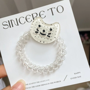 Détail de l'élastique à cheveux spirale transparent avec charm chat à pois noir et blanc