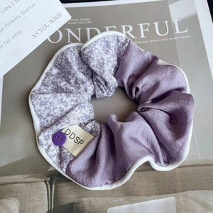 Détail d'un chouchou floral violet avec étiquette DDSP et texture satinée