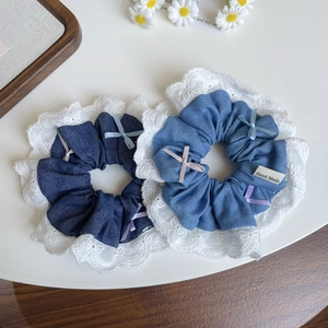 Détail de chouchous en jean avec nœuds roses, bordure dentelle et étiquette faite main