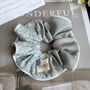 Détail d'un chouchou en soie à fleurs avec bouton décoratif et esthétique vintage