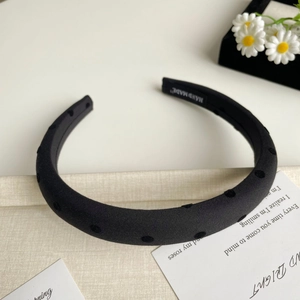 Détail du serre-tête rembourré noir fait main avec motif à pois et texture élégante