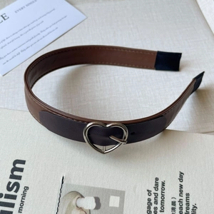 Detail of vintage leather headband with silver heart buckle and bicolor design