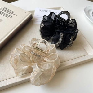 Bow hair claw clips with rhinestones in black and champagne on an elegant tray