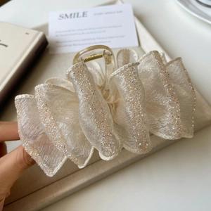 Detail of the layered organza bow hair claw clip with shimmering silver glitter accents