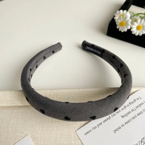 Détails d'un serre-tête en tissu gris foncé fait main avec motifs de cœurs noirs